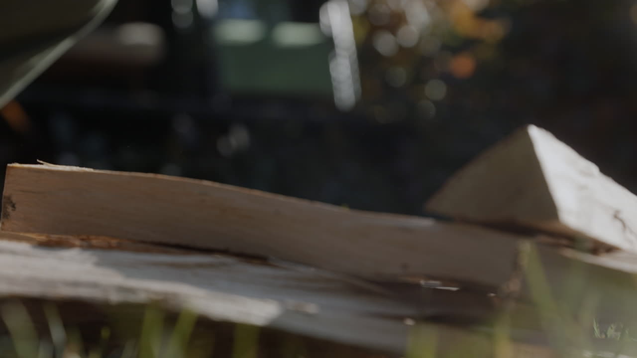 A man picks up wooden logs