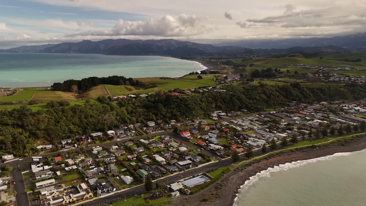 High-quality 4K drone footage captures a beautiful backwards-flying shot over the rugged Kaikoura coastline, revealing the majestic ocean and landscape of New Zealand's South Island