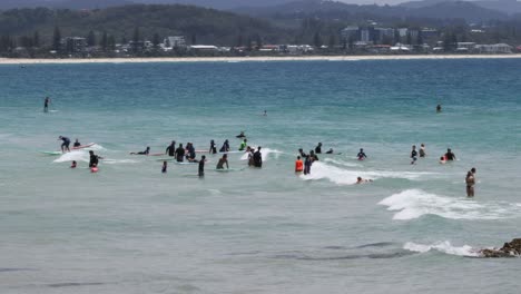 crowded beach scene with people enjoying the waves