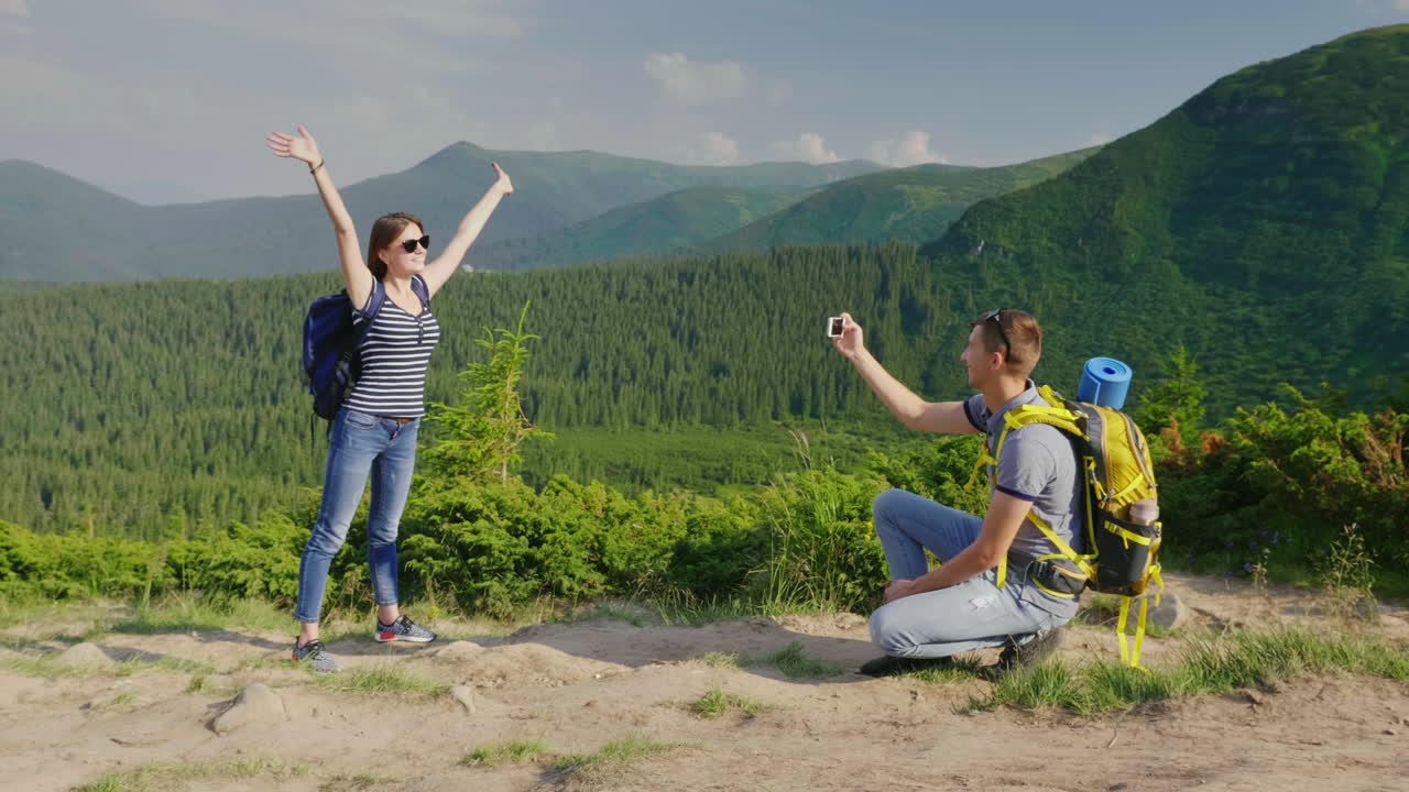 vacaciones en las montañas en verano un hombre toma fotos de su novia en un hermoso backgr