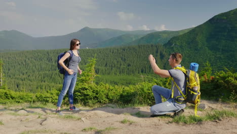 Vacaciones-En-Las-Montañas-En-Verano,-Un-Hombre-Toma-Fotos-De-Su-Novia-En-Un-Hermoso-Backgr