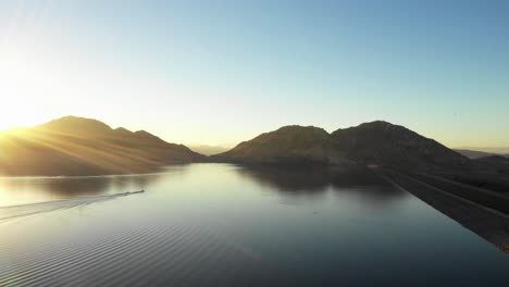 Barco-De-Esquí-Con-Un-Esquiador-Deslizándose-Por-Un-Lago-Como-De-Cristal-Hasta-Caer.