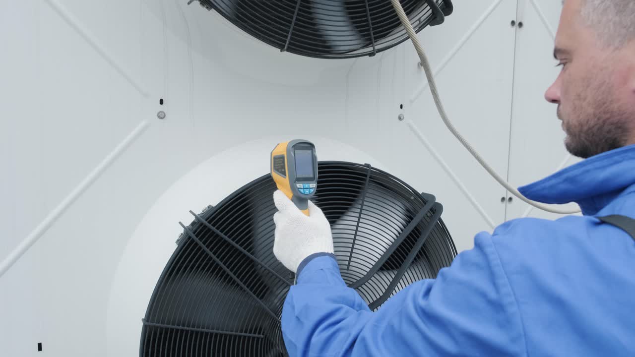 Technician uses a thermal imaging infrared thermometer to check the condensing unit heat exchanger