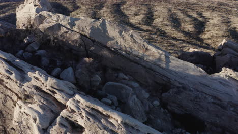 an aerial view of a cracked cliff in a dry, desert-like environment