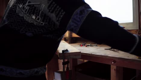 a man is securing the clamps firmly onto the wood in indre fosen, trondelag county, norway - static shot