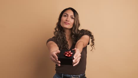 hispanic woman giving a present looking at camera