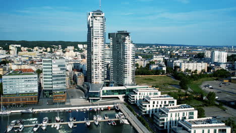 Aerial-view-of-modern-marina-with-boats-by-high-rise-buildings