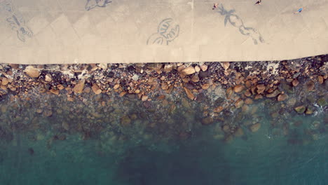 Serene-video-featuring-a-zenithal-view-of-the-Puerto-Vallarta-boardwalk,-capturing-the-waves-breaking-on-the-shoreline,-conveying-a-sense-of-peace-and-tranquility