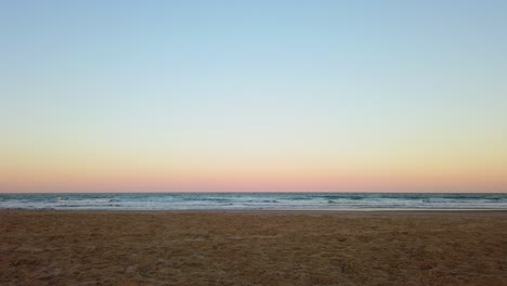 slow motion still shot of a relaxing sunset in the beach with clear sky and bright colors