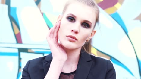 woman in urban setting with dark makeup and red nails