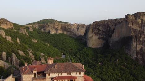 Meteora-Klöster-In-Griechenland-Bei-Sonnenuntergang,-Mit-Landschaftskulisse-Und-Grünen-Hügeln,-Luftaufnahme