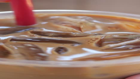 iced coffee in a plastic cup with a red straw