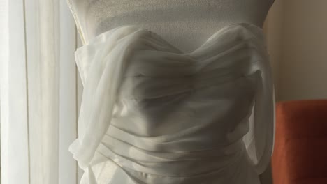 detail of wedding dress in hotel room during bride's preparation