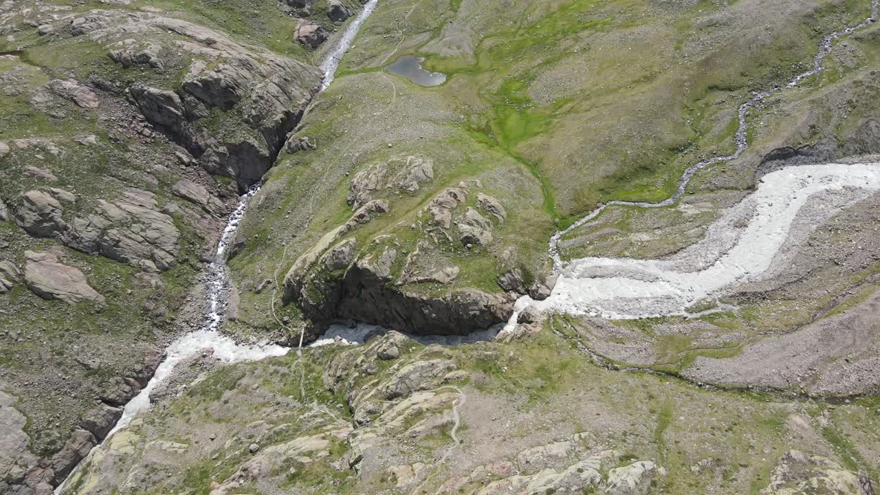 video de drones de gran angular de las hermosas montañas en el norte de italia con una cascada gigante y un río
