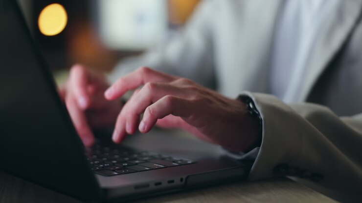 Hands typing on a laptop