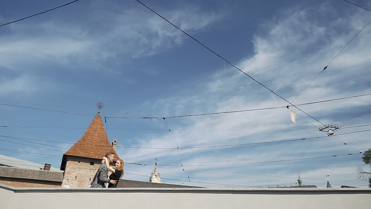 Couple on a rooftop near a tram