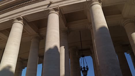 4k upward angle shot of the grand stone colonnade in st. peter’s square, vatican city, rome, highlighting architectural detail and historic baroque design under clear skies
