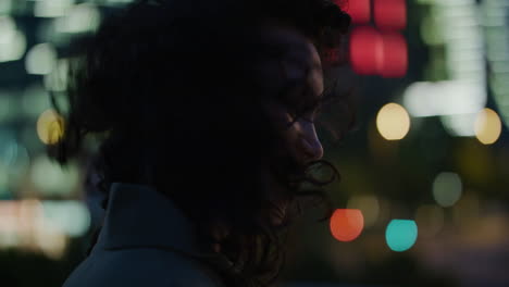 retrato de una hermosa mujer joven sonriendo usando un teléfono inteligente disfrutando de los mensajes de texto navegando por mensajes en línea en la colorida vida nocturna de la ciudad urbana mujer feliz en el teléfono móvil el viento soplando el cabello