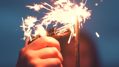 hand of person lighting a sparkler