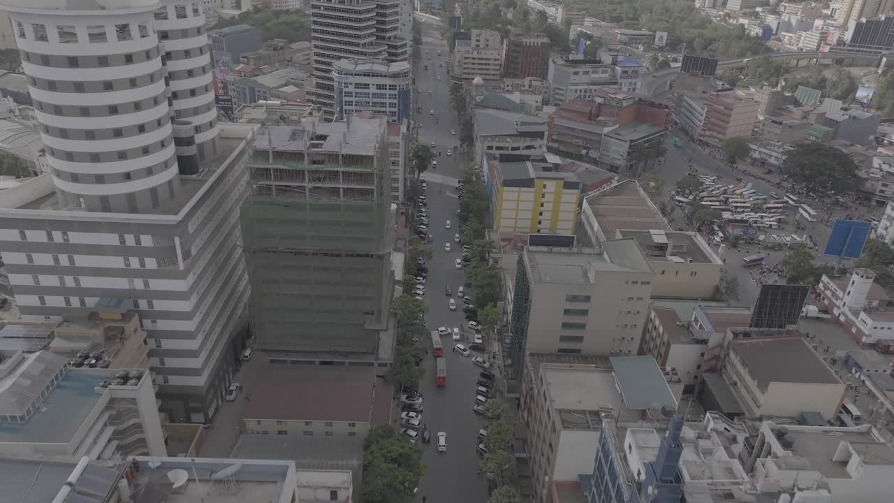 Drone aerial of Moi avenue in Nairobi, Kenya featuring urban traffic, matatus, pedestrians, retail buildings, and downtown infrastructure. Useful for concepts such as transportation and economy,