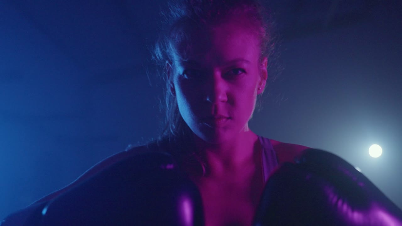 Boxeadora Determinada Treinando em Academia Enfumaçada com Iluminação Dramática