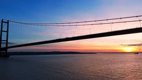 humber bridge bathed in the warmth of sunset, with cars seamlessly traversing its length, captured in a breathtaking aerial view