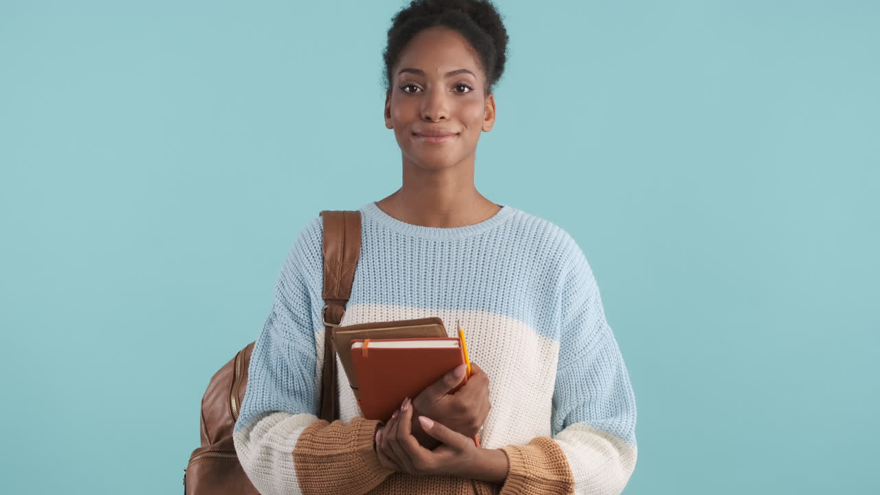 estudiante feliz posando con mochila, cuadernos y lápiz