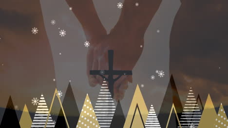 hands holding cross over abstract trees and falling snowflakes animation