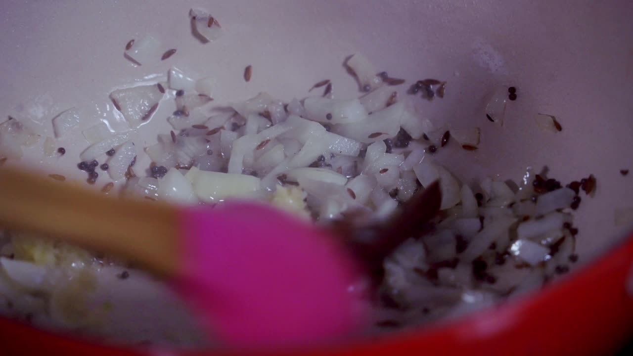Close up of ingredients cooking in a cast iron pot cooking papaya curry Green and ripe yellow organic fresh papaya pawpaw
