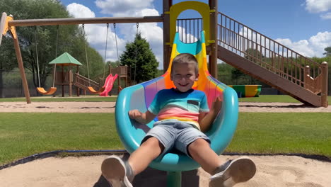 a boy enjoys sliding down a colorful playground slide