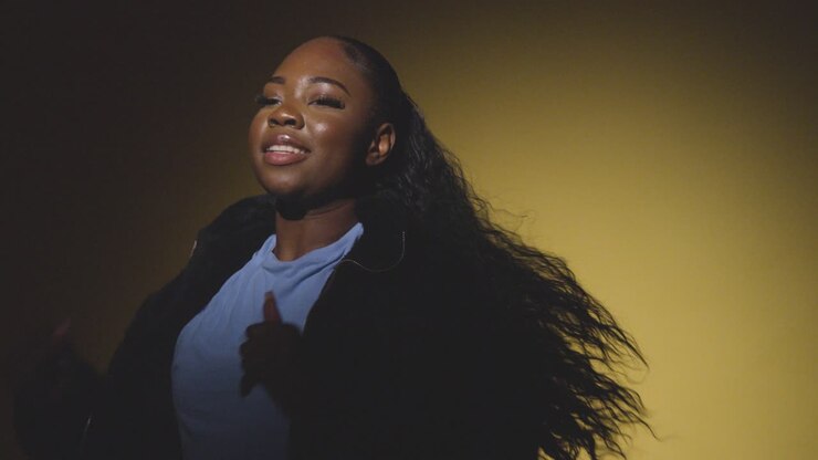 Head And Shoulders Studio Portrait Shot Of Young Woman Dancing In Spotlight Against Yellow Background 6