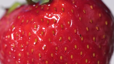 close up of juicy strawberries on a gray background. ripe red strawberries rotate in a circle