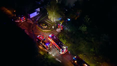 a group of firefighters putting out a fire at night