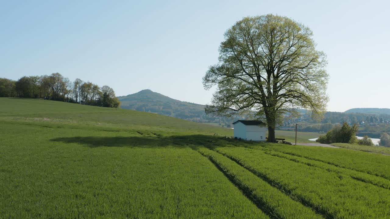 드론 - 잔디가 있는 들판에 있는 알 외로운 예배당의 공중 파노라마 샷과 7개의 산의 파노라마가 있는 도로 - siebengebirge 25p
