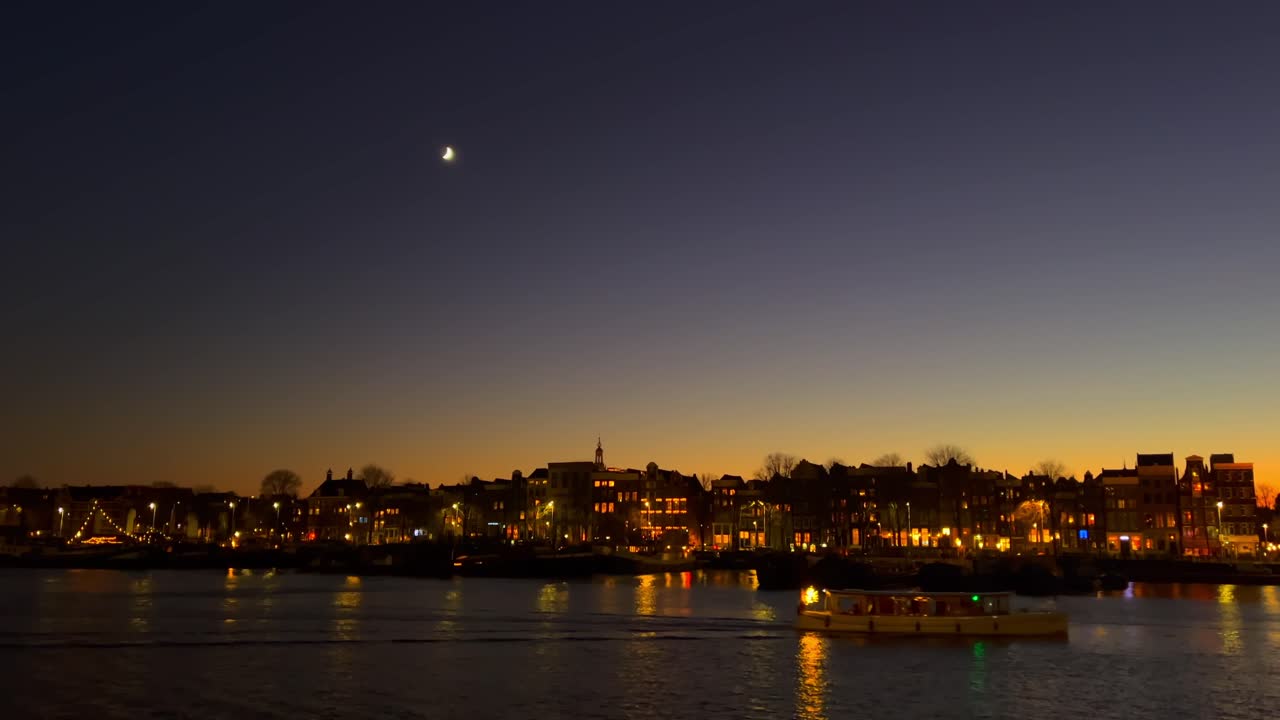 Fantastisk udsigt over Amsterdams bybillede med kanalhuse i skumringen og måne.
