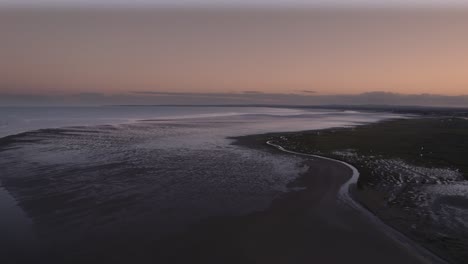 Vuelo-De-Drones-Sobre-La-Bahía-De-Dundalk-Durante-La-Puesta-De-Sol,-Volando-Hacia-El-Mar