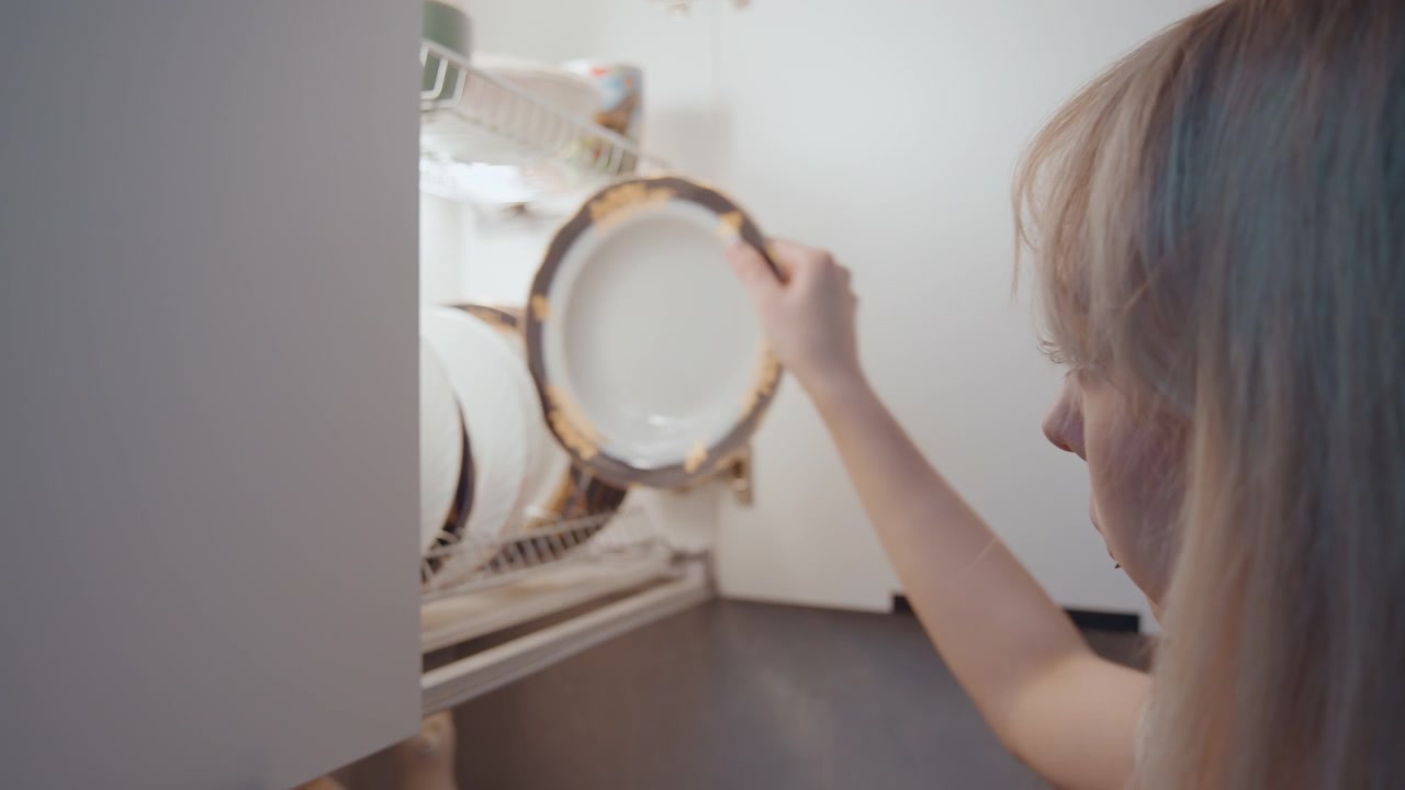 Lady serving dinner. Female gently arranges tableware. Quiet woman carefully sets meal. Serene lady meticulously prepares to present meal. Calm woman attentively reaches for plate in domestic setting