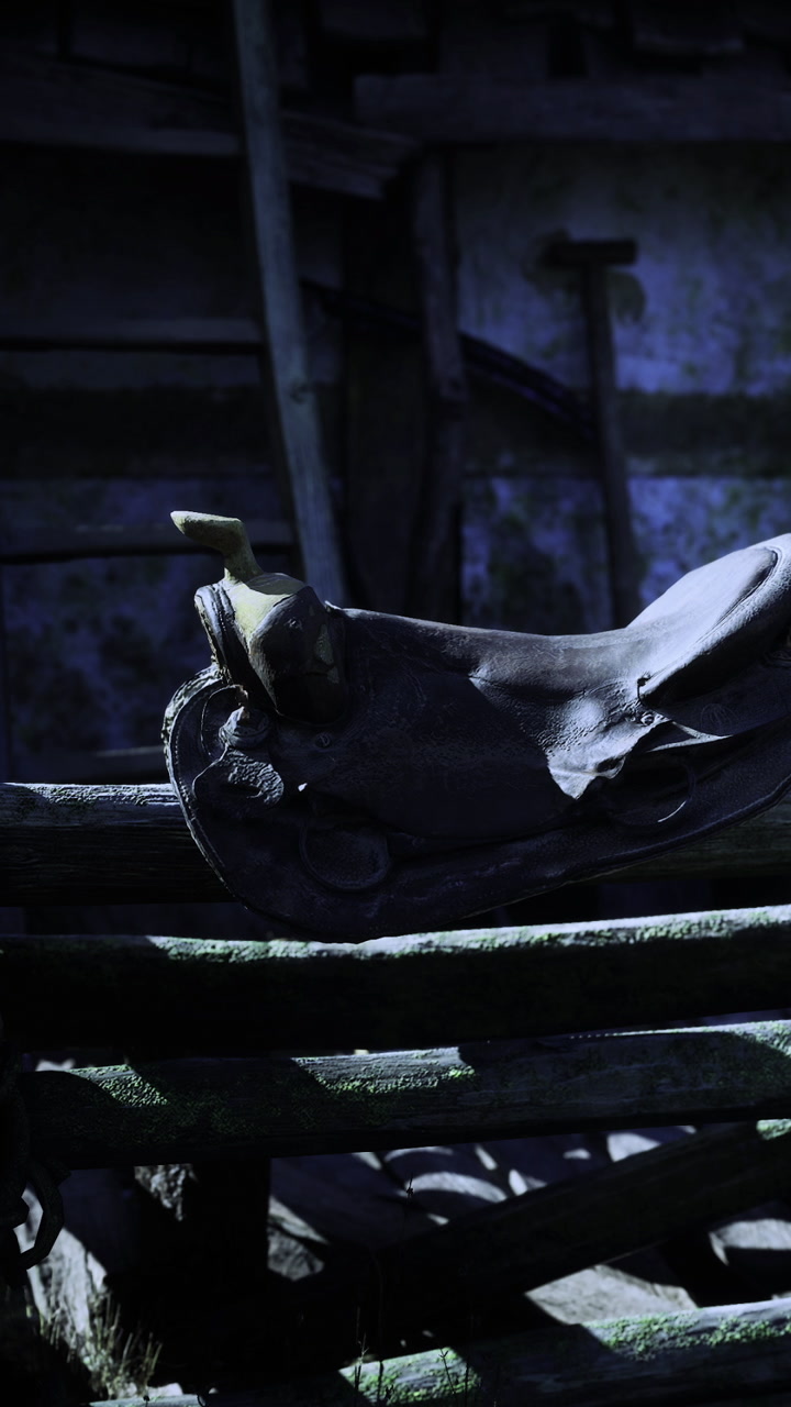 Leather saddle resting on a rustic wooden bench in a dimly lit barn