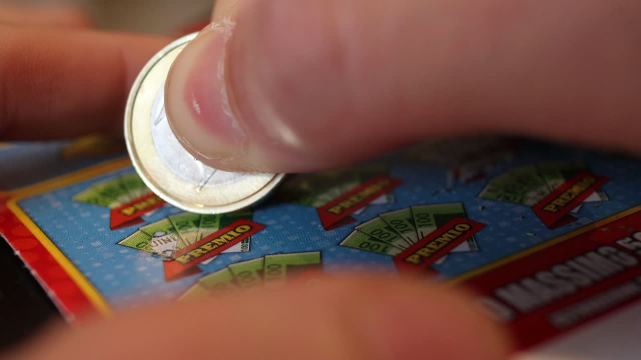 persona caucásica juega una tarjeta de rascar con una moneda de euro de cerca - concepto de adicción al juego