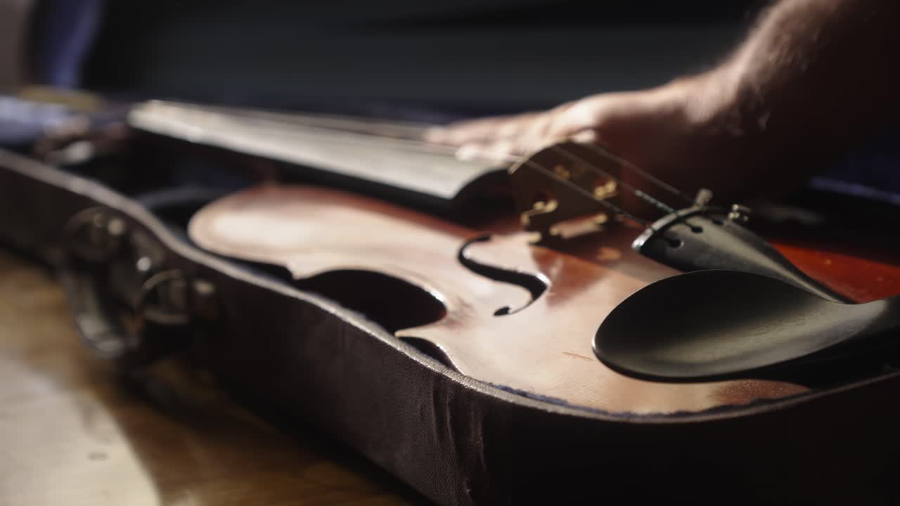 Musician places rare antique violin in protective instrument case