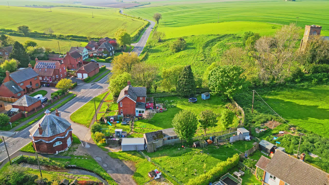 Aerial drone view captures Burwell village, once a medieval market town, including countryside fields, historic red brick houses, and the abandoned Saint Michael parish church on Lincolnshire's Wolds
