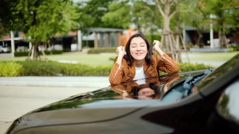 surprised young asian woman getting the new car. she hugged his car and was very happy. buy or rent car concept.