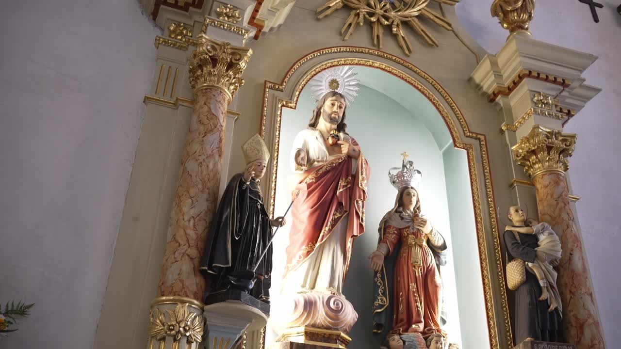 Altare dorato di una chiesa che mostra le statue del Sacro Cuore di Gesù e della Vergine Maria.