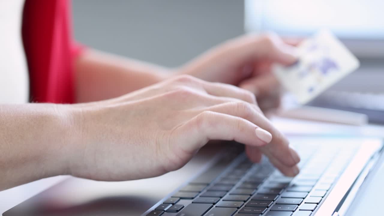 Woman doing online shopping with credit card on laptop
