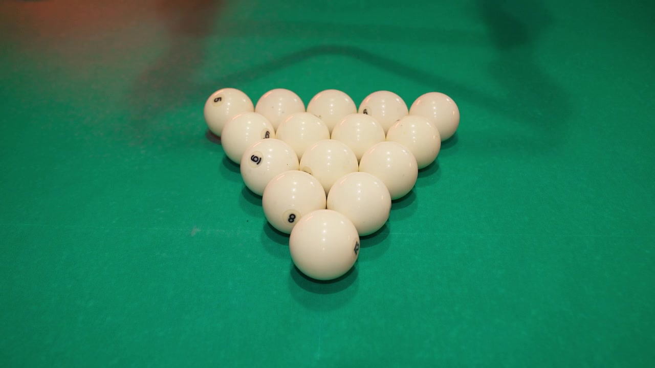 Close-up of Hands Racking Billiard Balls on Green Pool Table