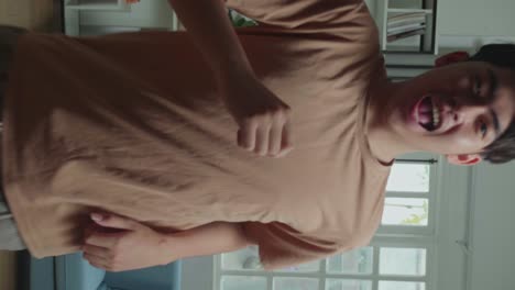 asian man dancing while shooting video content for social networks at home