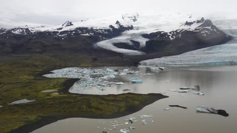 Glacier-in-Iceland-with-blue-ice-in-water-with-drone-video-moving-forward