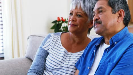 Senior-couple-sitting-together-on-sofa-in-living-room-4k