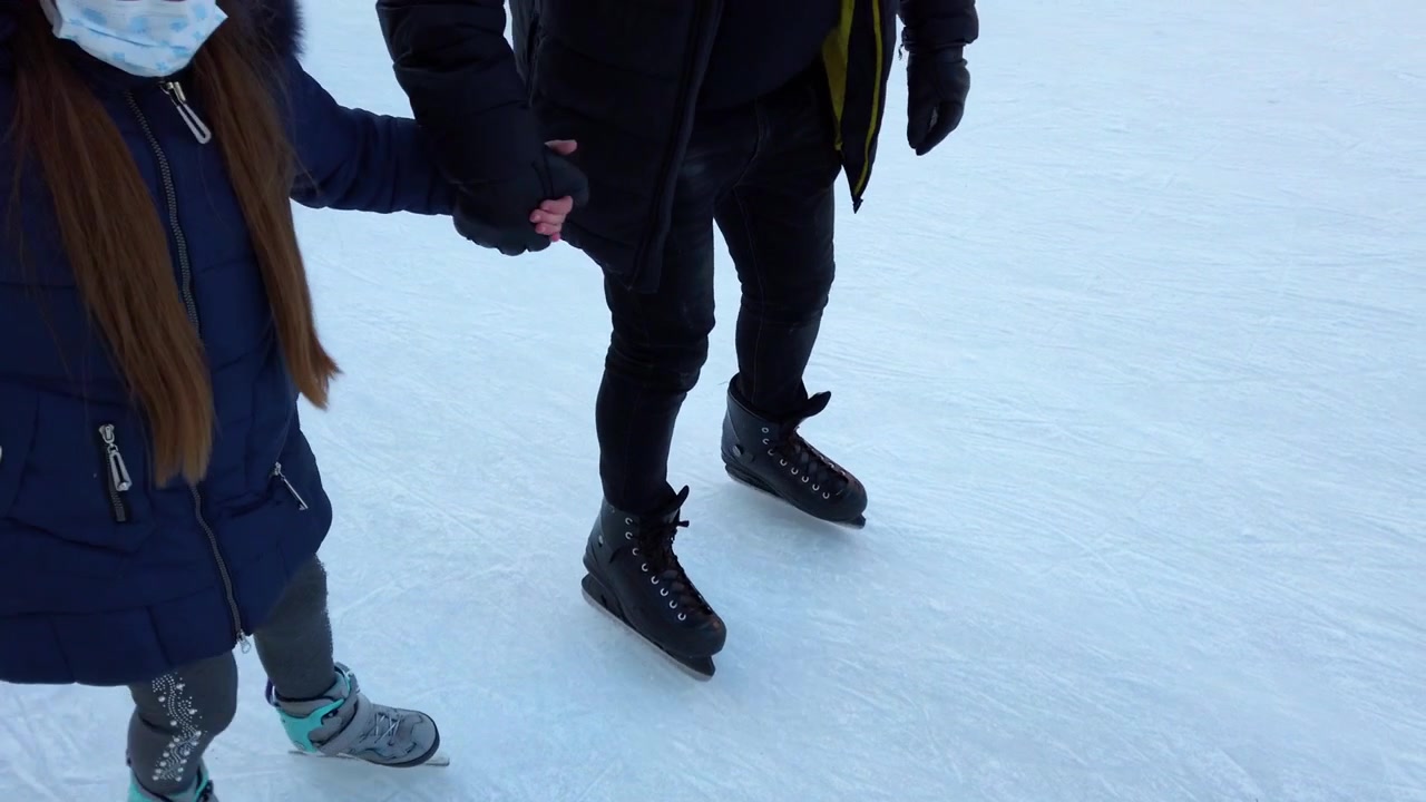 Menschen laufen auf einer Eisbahn Schlittschuh.