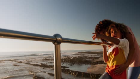 Mother-and-son-pointing-away-the-sea